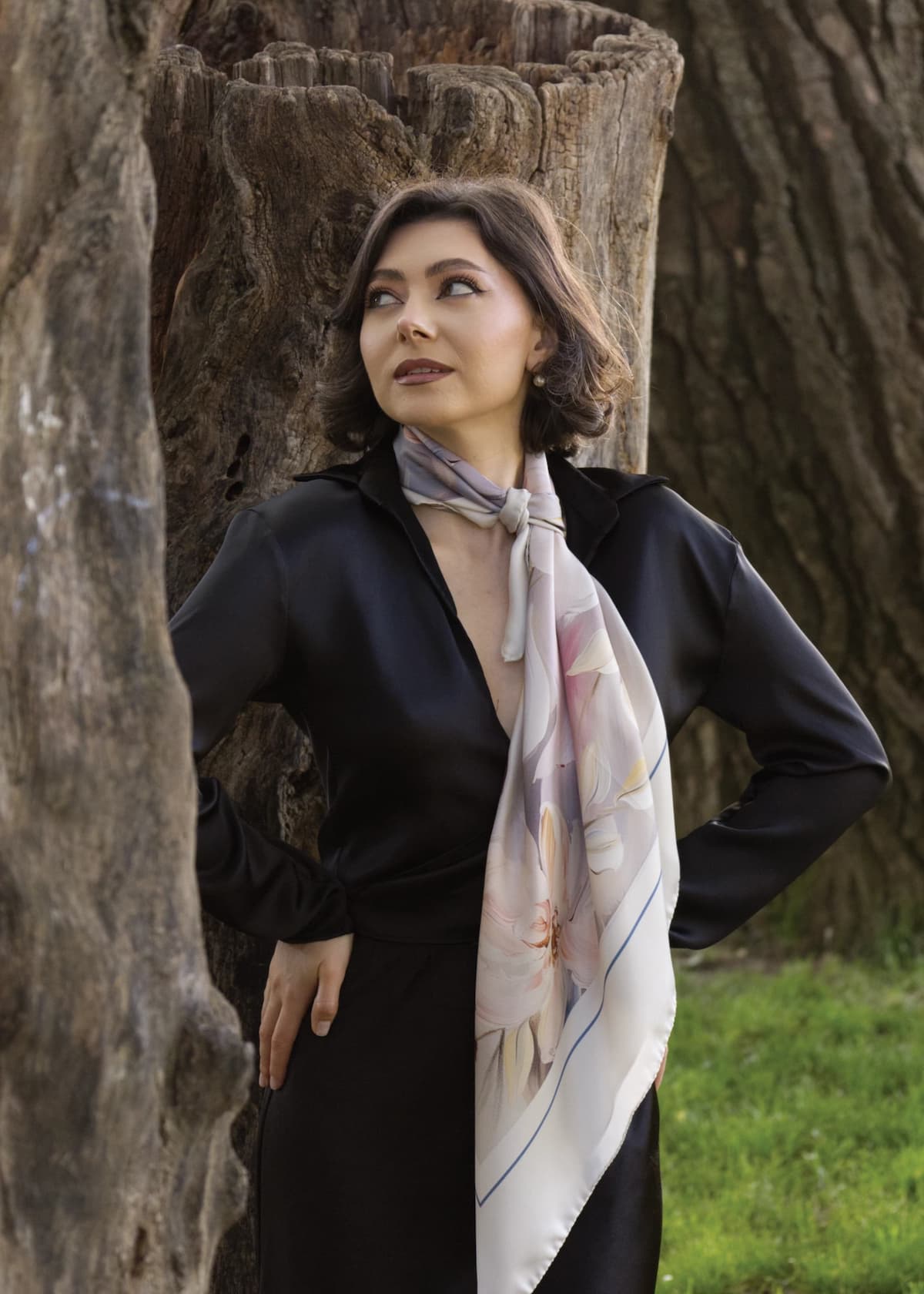 Maria, elegantă în rochie închisă, poartă cu grație eșarfa Gratitude MARLÚME din mătase naturală, un simbol al sufletului delicat și pasional care inspiră fiecare creație Marlume, unde feminitatea și emoțiile autentice se întâlnesc într-o poveste de recunoștință și rafinament.